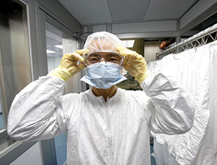 Photo of a student dressed in a mask and gown. Link to Closely Held Business Stock.
